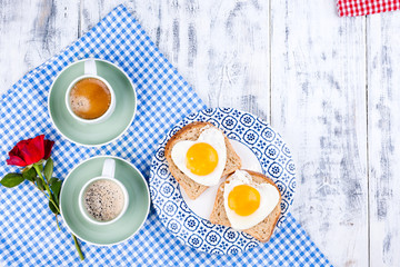 Flowers, Two cups of aromatic coffee and heart-shaped toasts for a romantic morning of lovers. Red rose, letter or note on the table. The concept of Valentine's Day and Mother's Day. Flat lay.  