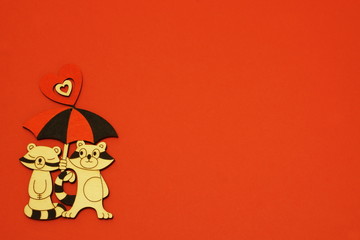 Vintage stylish decorative charming pair of raccoon lovers under bright umbrella decorated with heart on red background. Minimal background to Valentine's Day, Mother's Day with copy space.