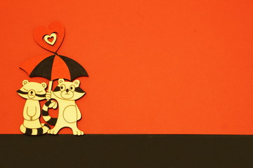 Stylish  vintage stylized raccoons in love under bright umbrella decorated with heart on border of red and black background. Minimal background to Valentine's Day, Mother's Day with copy space.