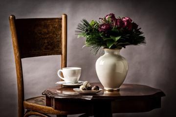 bouquet of flowers, on old coffee-table with old chair and old antique vase and  chocolates