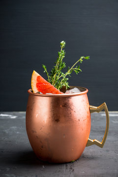 Grapefruit moscow mule in copper mug on the rustic background. Selective focus. Shallow depth of field. 