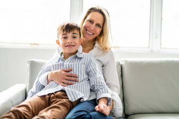 A people and family happy boy with mother on sofa at home