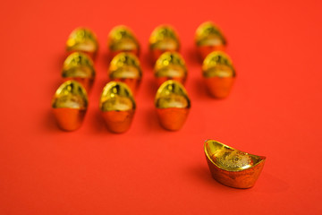 Chinese Gold Ingot for Chinese new year celebration shot with isolated red background