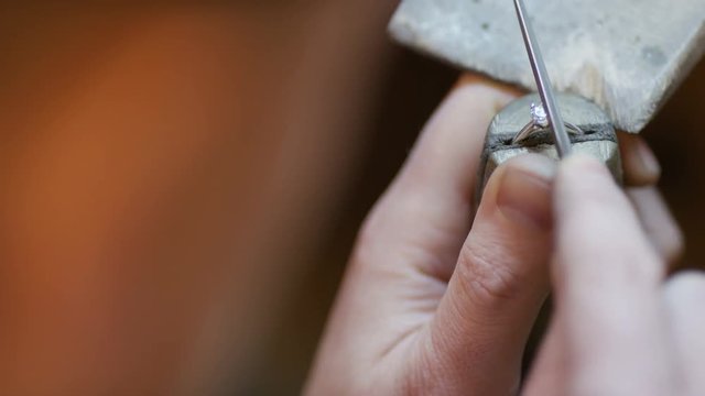Hands of a jeweller filing the clasps of a ring