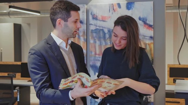 Colleagues standing and looking food from the flyer