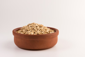 Dry rolled oatmeal in bowl isolated on white background.