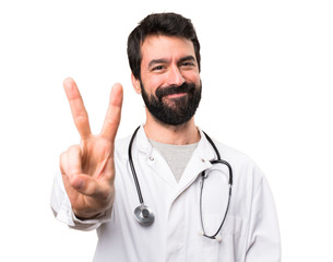 Young doctor counting two on white background