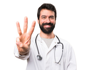 Fototapeta premium Young doctor counting three on white background