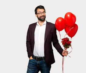 Man in valentine day posing and laughing looking to the front over isolated grey background