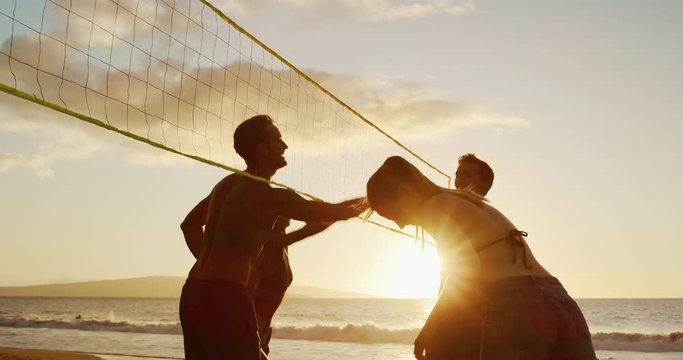 Friends playing beach volleyball cheering and put hands up at net, slowmotion cinematic summer lifestyle