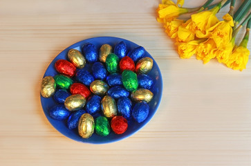 easter background with daffodils and chocolate eggs