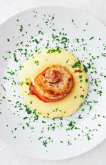 roatsed in bacon rabbit loin on potato mash decorated with parsley