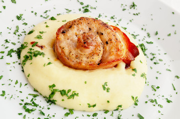 roasted rabbit loin wrapped into bacon on mashed potato sprinkled with parsley