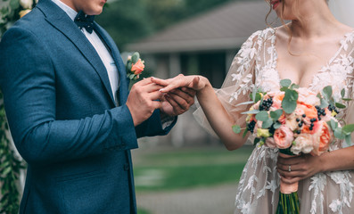Wedding rings. Selective focus. Close-up. The groom wears the wedding ring to the bride during the...