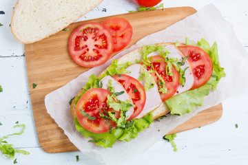 baguette sandwich with ham, tomatoes and lettuc