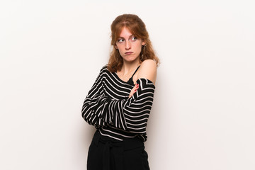 Fototapeta premium Young redhead woman over white wall making doubts gesture while lifting the shoulders