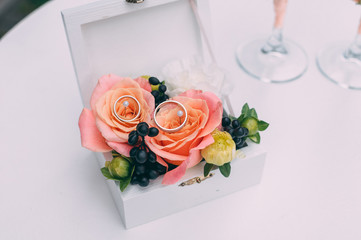 Two wedding glasses and bridal bouquet on stone in summer garden