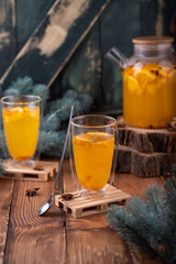 glass of orange juice and oranges on wooden table