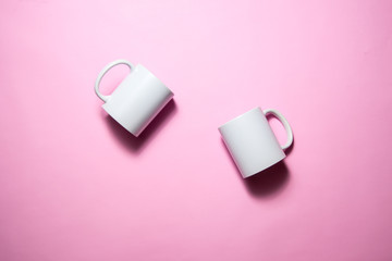 White coffe mugs on pink background 