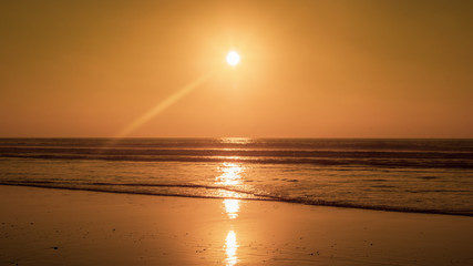 Sunset on the Main Beach at Agadir Morocco with people silhouetted while playing, fishing and surfing in waves
