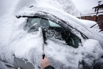 Krasnodar, Russia-December 26, 2018. Brush the snow from the car. Extreme snowfall in european city