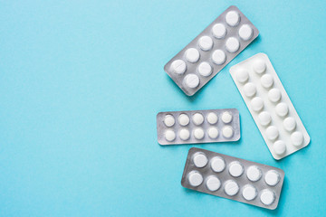 Pills on blue background top view. 