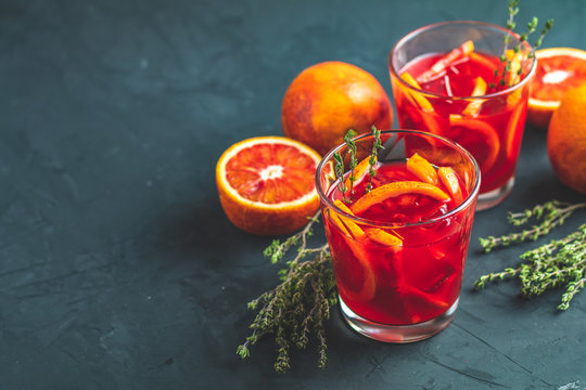 Red orange juice in a large glass or blood orange sparkling vodka cocktail or aperitif with campari