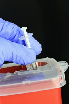 Hospital Staff Using A Sharps Container For Bio Hazard Needles