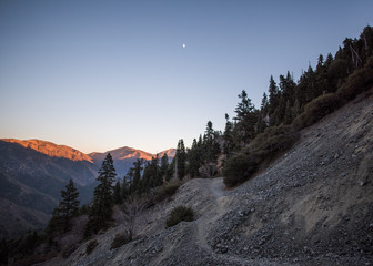 Dramatic alpenglow and moonrise over mountains