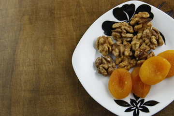 Walnuts and dried apricots on a saucer