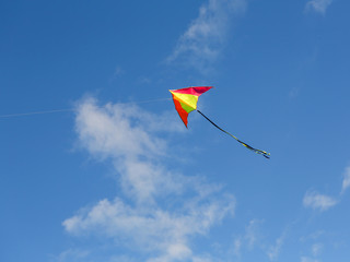 Kite flying. Bright kite against the blue sky. Sunny day.