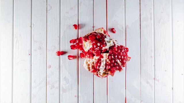 Stop motion on pomegranate seeds is peeled in the shape of a heart, randomly on the table