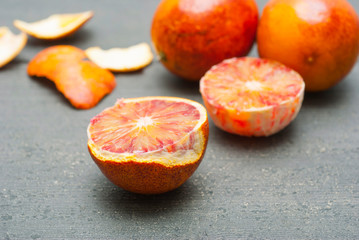 peeled blood oranges on dark wood table