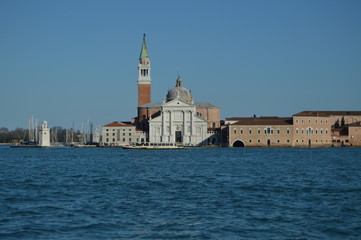 Fototapeta na wymiar Facade Of The Church Of San Giorgio Maggiore And Its Spectacular Bell Tower With A Vaporeto Crossing Through In Venice. Travel, holidays, architecture. March 28, 2015. Venice, Veneto, Italy.