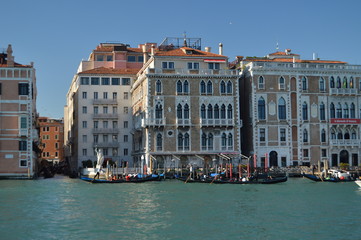 Naklejka premium Grand Canal With Gondolas Walking To Tourists Background A Picturesque Venetian Palaces In Venice. Travel, holidays, architecture. March 28, 2015. Venice, Veneto region, Italy.