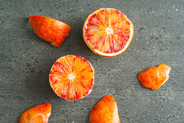 peeled blood oranges on dark wood table