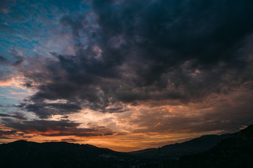 Dramatic purple and orange cloudy sunset with mountain silhouette