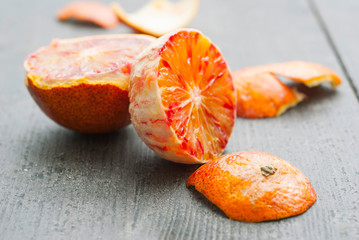 peeled blood oranges on dark wood table