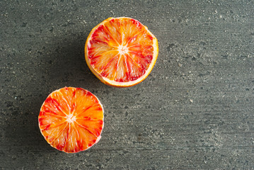 peeled blood oranges on dark wood table
