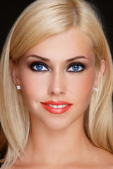 Young beautiful smiling tanned blonde woman with smoky eye make-up