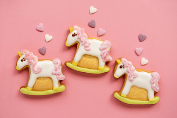 Naklejka premium Unicorn shaped sugar cookies decorated with pastel royal icing on pink background