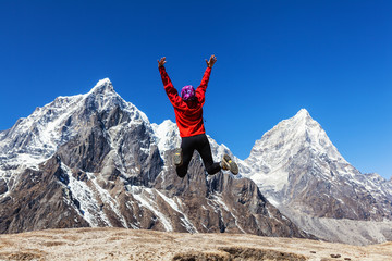 Rear view of happy female mountaineer jumping for a joy.Motion blur 