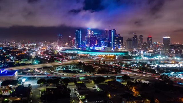 4K aerial urban hyperlapse ( timelapse in motion ) clip of downtown and freeways interchange at night and convention center