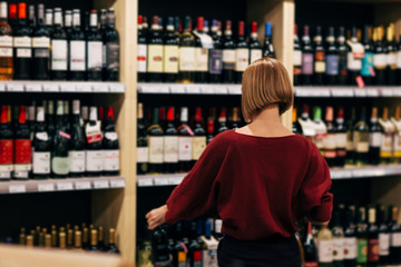 Photo from back of young woman in wine shop