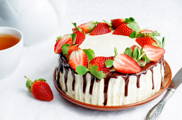Sponge cake with cream, chocolate and strawberry