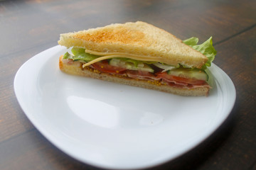 Sandwich with bacon, cheese and fresh vegetables