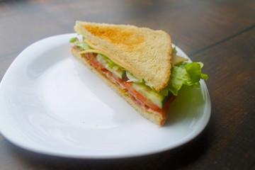 Sandwich with bacon, cheese and fresh vegetables