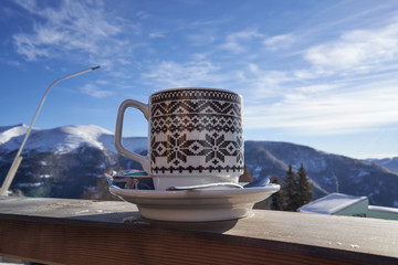 Cup of tea captured on a railing with blue sky in the background