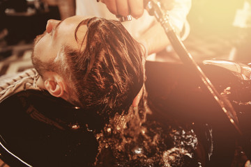 Barber massages head client, nanansit shampoo for hair. Concept preparation cutting and styling