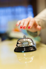 A female hand ringing silver service bell